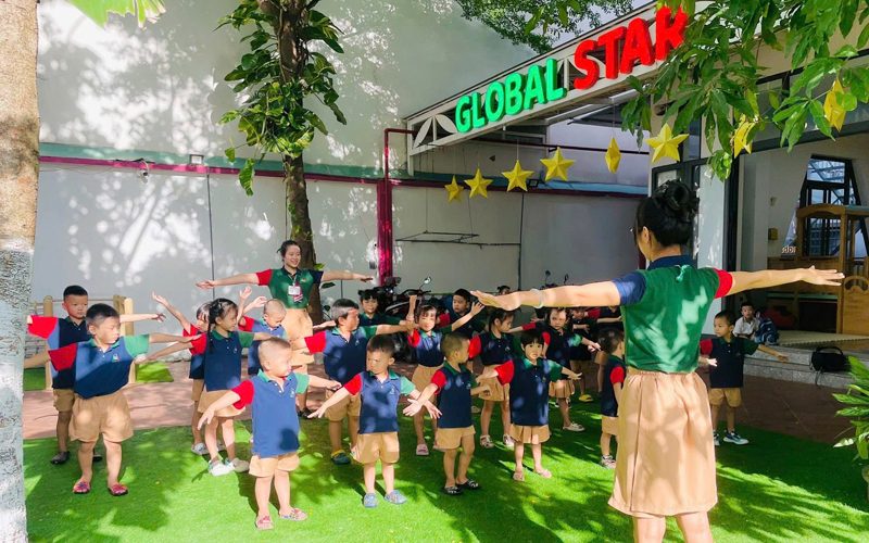 Cô và các bé tập vận động ngoài sân cỏ của trường